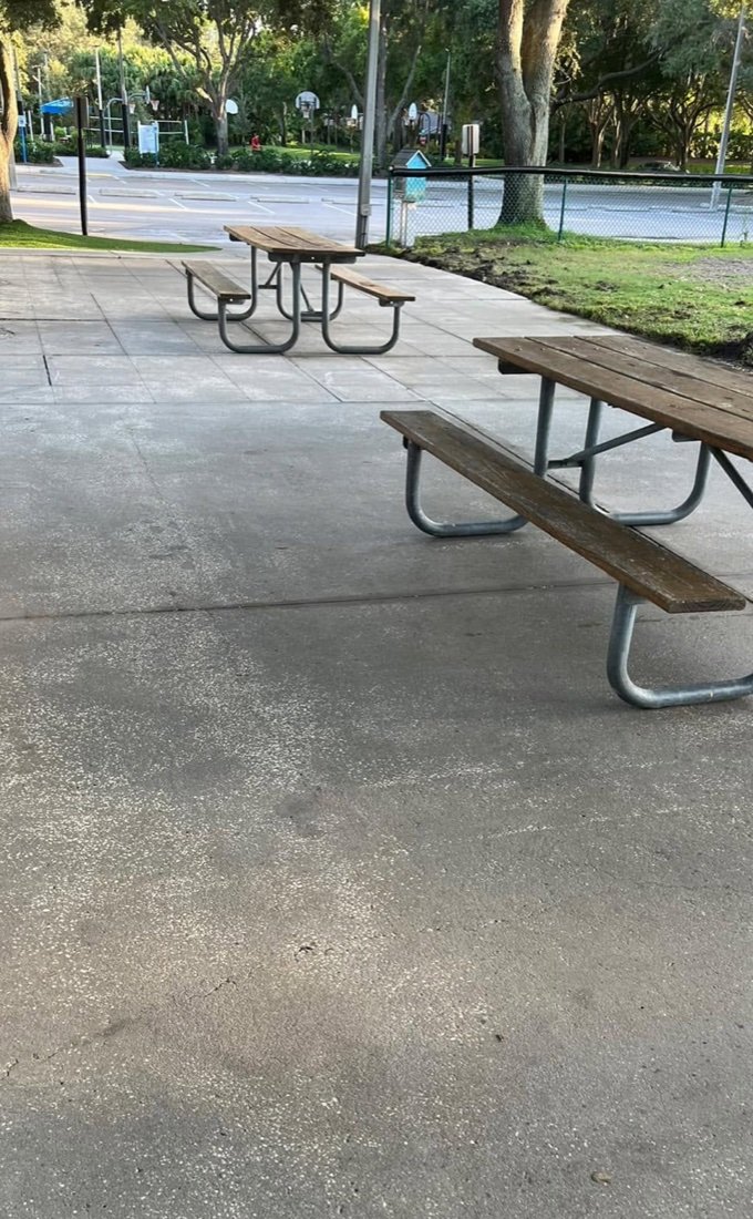 Clean concrete patio with picnic tables after cleaning